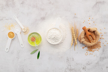 The ingredients for homemade pizza dough with wheat ears ,wheat flour and olive oil set up on white concrete background. top view and copy space. - 582361463