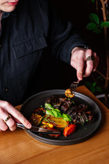 a man eats grilled beef in bbq sauce