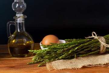 bunch of wild asparagus with a jar of olive oil and eggs