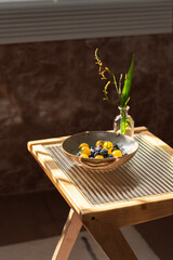 A bowl of fresh fruits and plants on the coffee table.