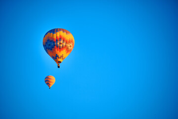 Obraz premium Flying hot air balloons against bright blue sky