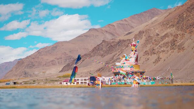 4K shot of statue of Guru Padmasambhava besides the Sani Lake near the Sani Monastery in Sani village near Padum in Zanskar, Ladakh, India. Statue besides the holy lake and in front of mountains