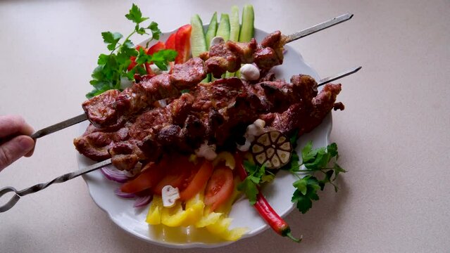 Traditional Russian shashlik on a barbecue skewer with paprika as closeup on an old board . High quality photo