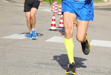 elderly runner with the skin of the thigh that vibrates during the race in the city