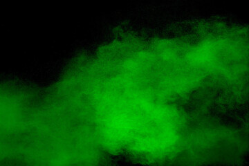 Abstract green powder explosion on black background.Freeze motion of green dust cloud.