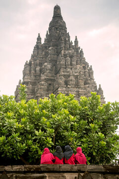 Rear view of women standing at Prambanan temple against clear sky