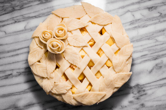 Overhead view of peach pie on marble counter