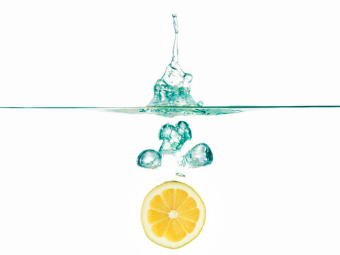 Lemon Slice In Water Against White Background