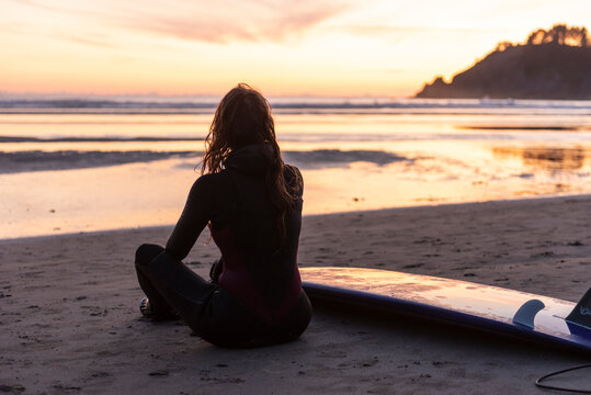 Surfer taking in the sunset along the Oregon coast