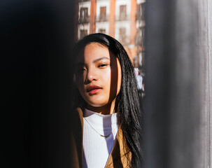 portrait of asian girl illuminated by the sun with shadows outdoors