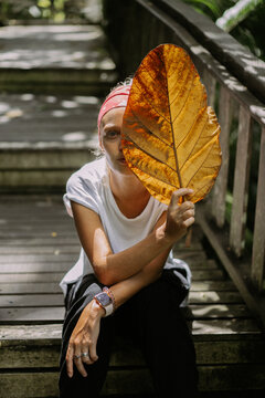 Woman traveler with palm leaf. Ubud, Bali