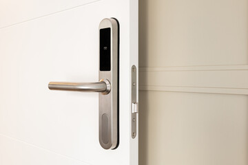 Open front door with electronic mortise lock and handle. The door is opened with a combination of a digital code or a plastic card. Modern door opening and property security systems.