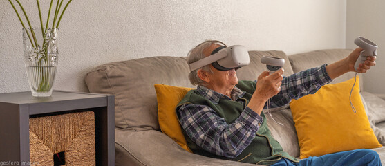 Older man playing with virtual reality glasses in widescreen format