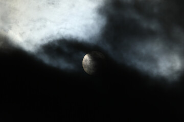 Sun disk behind backlit clouds