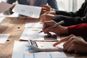 Teamwork with businessman analyzing cost graphs on table at conference room.