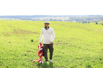 Man waving American flag standing in grass farm agricultural field , holidays, patriotism, pride,...