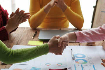 Shaking hands, Teamwork with businessman analyzing cost graphs on table at conference room.