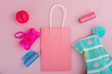 pet accessories, animal goods and clothes with shopping bag on a pink background, copy space, top...