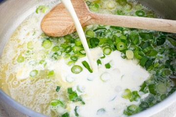 Lauch Zwiebel in einer Pfanne angebraten mit Sahne abgelöscht 
