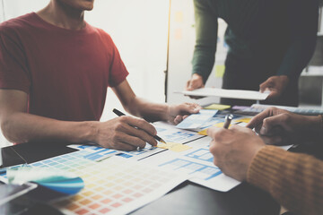 ux developers, UI designers Asian group data researchers brainstorm on tabletop mobile app...