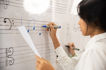 female student sitting taking notes music teacher.