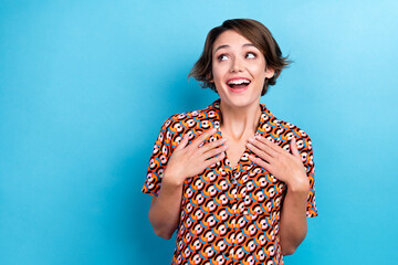 Portrait of positive astonished person hands touch chest open mouth look empty space isolated on blue color background