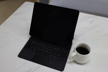대리석 책상위 자판이 있는 모바일 패드와 커피 한잔