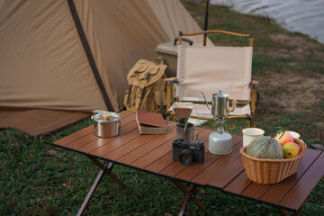 Outdoor activity concept, Camping area with tent and equipment for camping on the table near lake