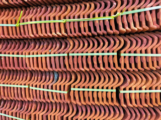 Roof tiles. Decorative background design. Piles of new roof tiles in many rows with different number in any column. Selective focus.
