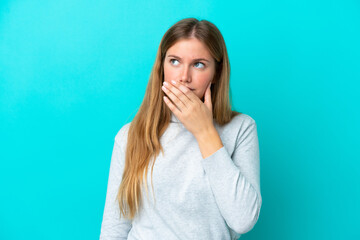 Young blonde woman isolated on blue background having doubts and with confuse face expression