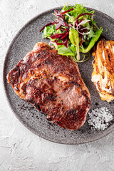 Grilled Ribeye Steak on plate with Potato gratin and salad