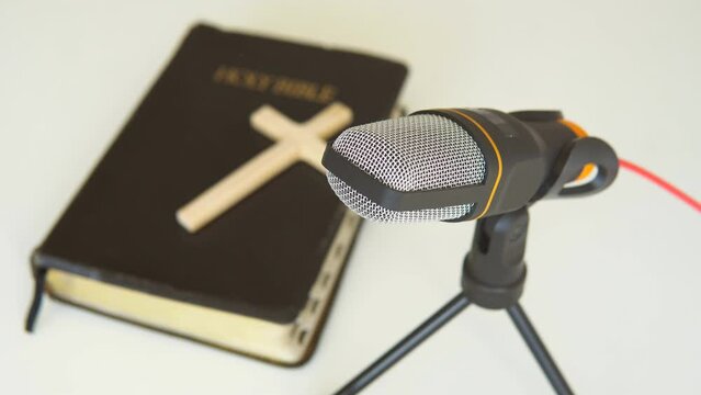 Bible book with microphone. Christian radio broadcast. Man records a online podcast.