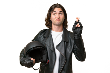Young handsome man with a motorcycle helmet isolated on green chroma background with fingers crossing and wishing the best