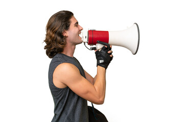 Naklejka premium Young sport handsome man isolated on green chroma background shouting through a megaphone