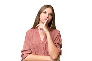 Young beautiful blonde woman over isolated background having doubts while looking up