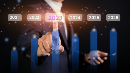 Future online business concept 2023. Businessman touch virtual screen with 2023 icon to create efficient corporate network.