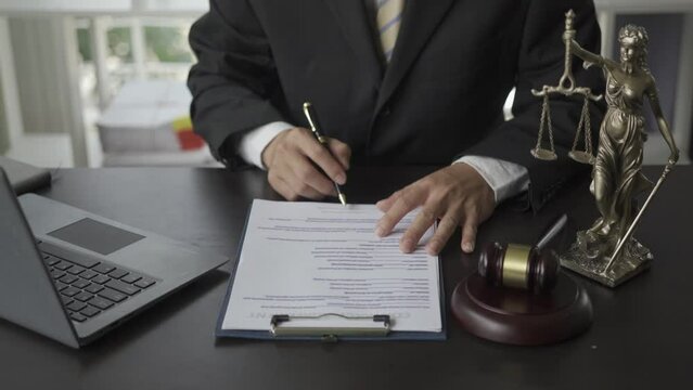 Lawyer working with contract documents, laptop and hammer scales of injustice online legal counsel in the office