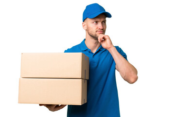 Delivery caucasian man over isolated background and looking up