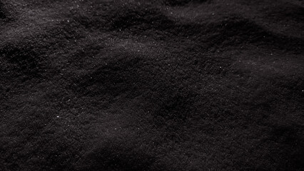 Black sand surface.  Low key photo. Selective focus photo. Dark volcanic surface