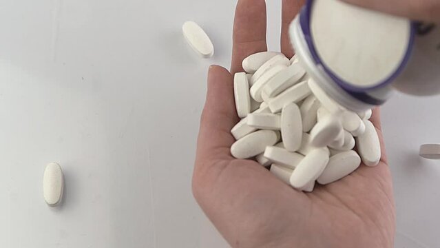 Pour a dose of tablets into your hand. Tablet treatment. Vitamins, dietary supplement, painkillers and antipyretics. Pharmaceutics. Pharmacy. White pills. Health treatment