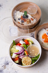 top view of vegetable salad with cheese and other breakfast boxes on a white background