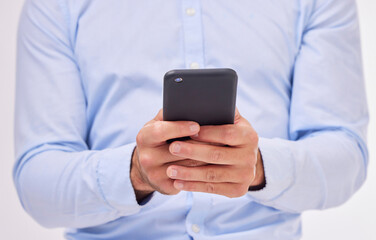 Business man, hands and typing with phone in studio isolated on a white background. Cellphone, networking and male professional with smartphone for texting, social media or internet browsing online.