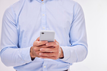 Hands, business man and typing with phone in studio isolated on a white background. Cellphone, networking and male professional with smartphone for texting, social media or internet browsing online