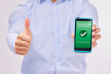 Man, hands and phone with thumbs up for transaction approval against a white studio background. Hand of male showing thumb emoji, yes sign or like for electronic purchase or ecommerce on smartphone