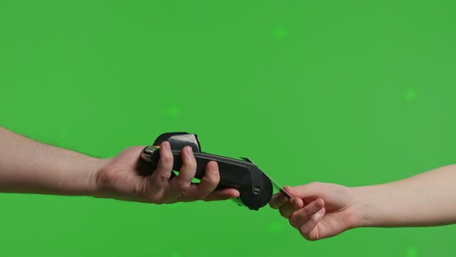 Close-up of hand hold wireless bank payment POS terminal to process acquire credit card payments on green screen background. Copy space mock up advertising
