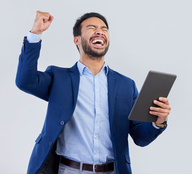 Winner, excited and tablet with man in studio for good news, success and bonus. Pride, yes and celebration with male and cheering isolated on gray background for achievement, pride and job promotion