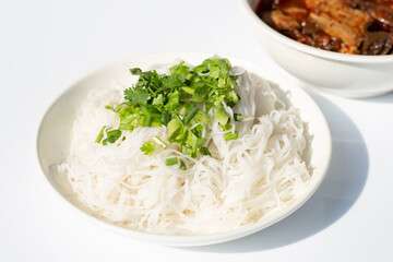 Rice noodles with Northern Thai pork curry in white plate on white background.