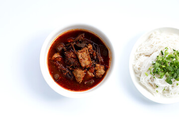 Rice noodles with Northern Thai pork curry in white plate on white background.