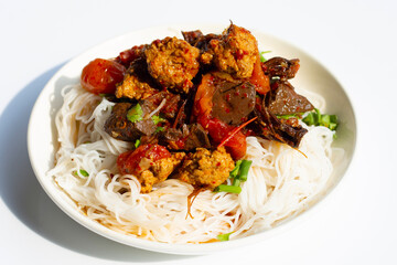 Rice noodles with Northern Thai pork curry in white plate on white background.