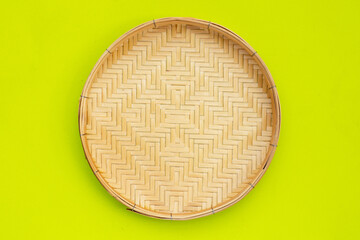 Bamboo weave plate on green background.